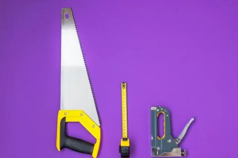 Hard work Hand tools yellow ruller, stapler, tape measure hand saw Stock Photos