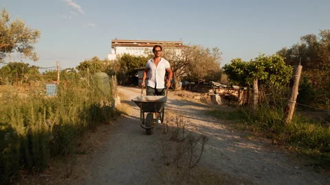 Hard Work For A Man In The Countryside With The Wheelbarrow Stock Footage 283473674