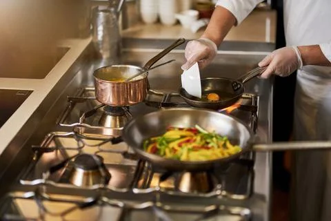 Hard-working chef preparing a delicious meal on stove Stock Photos