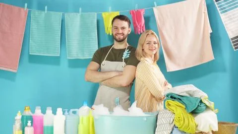 Hard-working couple is ready to help you with Laundry. Laundry service Stock Photos