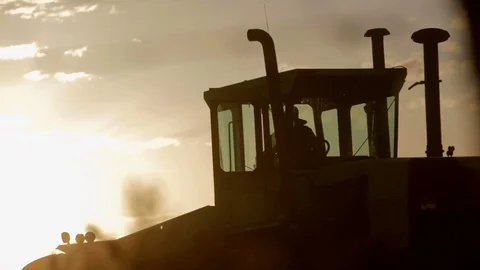 Hard working farmer climbing out of tractor after a long day of labor in Stock Footage 98394903