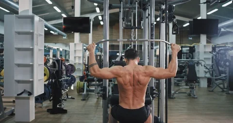 Hard working guy at gym doing exercises on his triceps muscles concentrated with Stock Footage 115936987