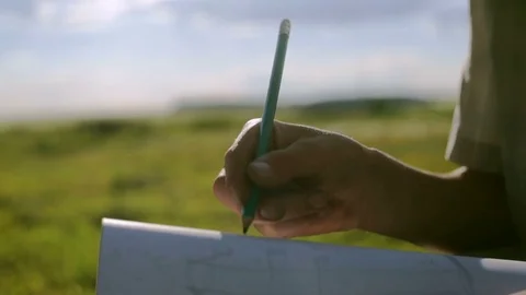 Hard-working guy paints a pencil on paper. Close-up dirty hand against a Stockbeeldmateriaal 78444530