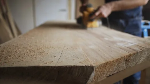 Hard working man is working in his shop on the plank of wood on the bench, Stock Footage 89305921