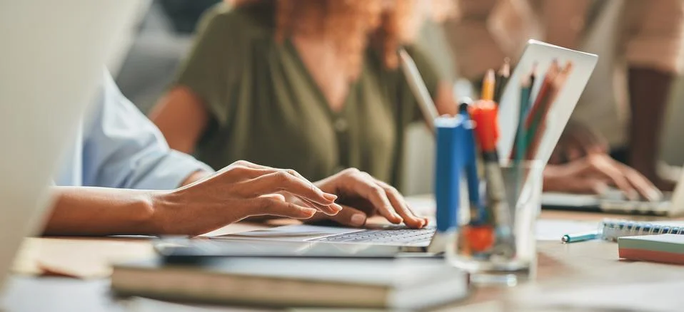 Hard-working person typing while working on the laptop Stock Photos