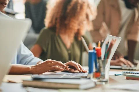 Hard-working person typing while working on the laptop Stock Photos