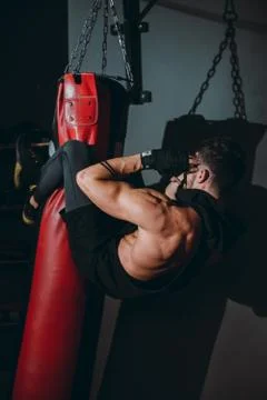 Hard workout exercises guy doing abs while holding with legs the boxing punching Stock Photos