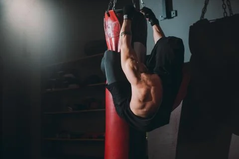Hard workout exercises guy doing abs while holding with legs the boxing punching Stock Photos