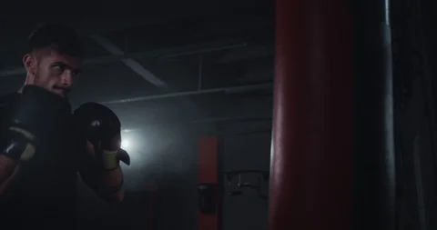 Hard workout in a gym class closeup brutal athletic guy boxing hard in a Stock Footage 119977050