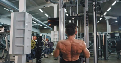 Hard workout at gym young athletic man lifting up the weights concentrated Video stock 115937717