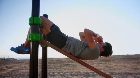 Hard workout of Hispanic guy exercising at beach training place at morning Stock Footage 109419451