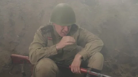 Hardened Soviet soldier sits in the trenches during the battle and smokes. 스톡 동영상 65964504