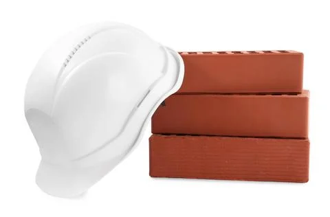 Hardhat with bricks isolated on white. Construction materials and safety eq.. Stockfoto's