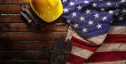 Hardhat, gloves, and tools on US American flag. Strong American workforce o.. Stock Photos