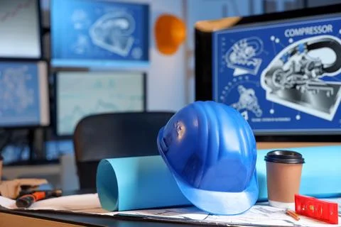 Hardhat with house plan and coffee cup on engineer's desk in office Stock Photos