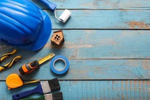 Hardhat with set of construction tools on blue wooden background Stock Photos