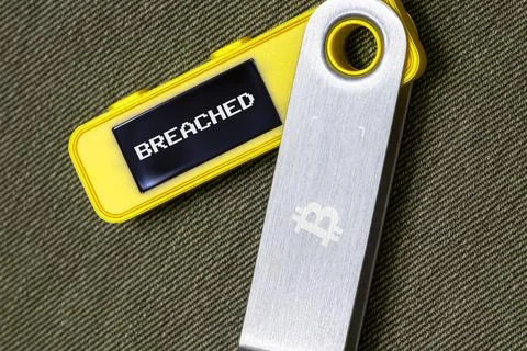 Hardware Bitcoin wallet with breached message on screen Stock Photos