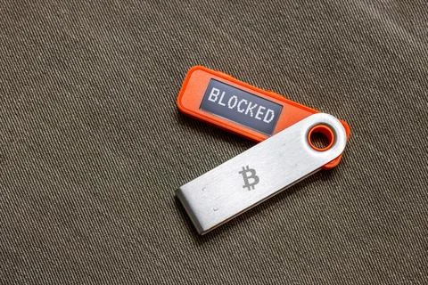 Hardware Bitcoin wallet with message Blocked on screen Stock Photos