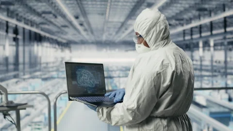 Hardware designers in microchip smart factory use laptop to analyze readouts Stock Footage 333378534