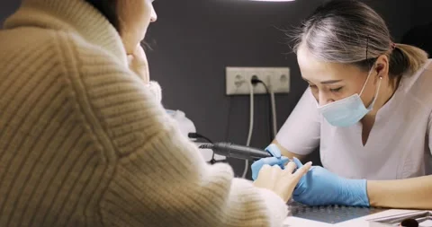 Hardware manicure, master is removing the gel coating from the woman's nails. Vídeo Stock 145470566