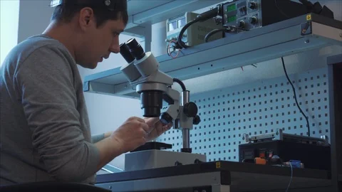 Hardware repair Laboratory , engineer uses microscope to repair mobile device Video stock 105971485