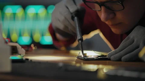 Hardware. Repair technician equipped with tools for tin bonding process in e Stock Footage 279933739