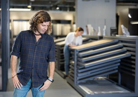 In hardware store, thoughtful man reflects on price-quality ratio of options for Foto stock
