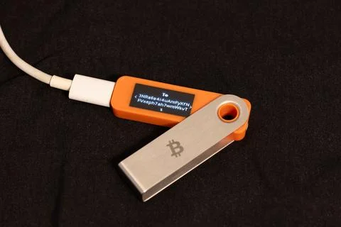 Hardware wallet displaying cryptocurrency address on dark surface Stock Photos