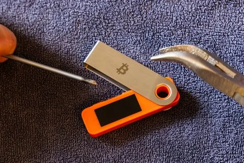 Hardware wallet physical attack with tools on dark grey towel indoors Stock Photos