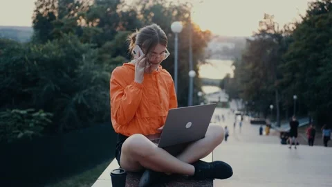 A hardworking and optimistic girl talks on the phone, smiles broadly, while Stock Footage 160626520