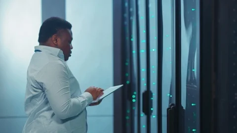 Hardworking black IT engineer using tablet performing and managing data center Video stock 119782304