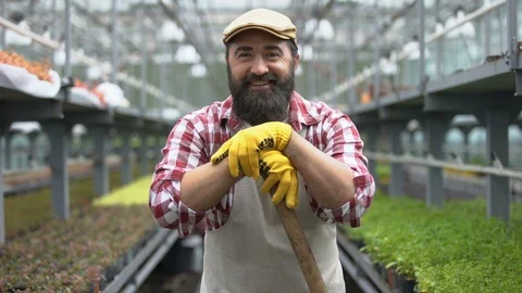 Hardworking farmer smiling at camera in greenhouse, employment in agriculture Video stock 118935447