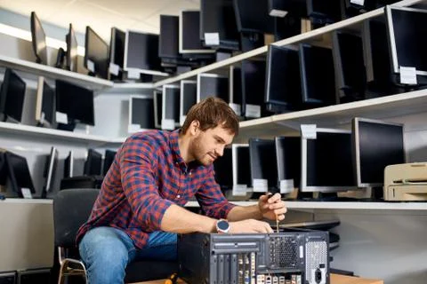 Hardworking guy fixes technical problems with the computer Foto stock