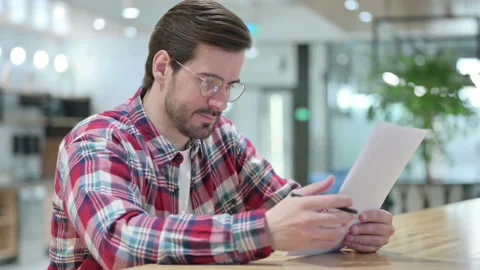 Hardworking Male Designer Reading Documents Video stock 139704720