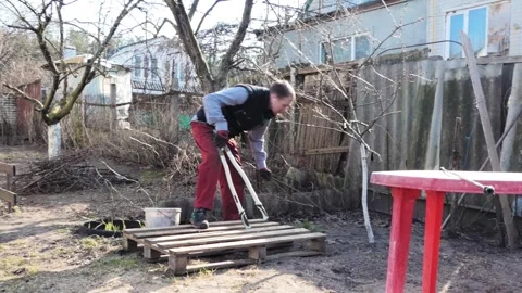 Hardworking Man Cleaning Up and Maintaining Spring Garden with Garden Tools Stock Footage 345043974