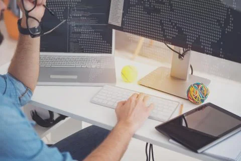 Hardworking man using laptop and computer in an office 库存照片