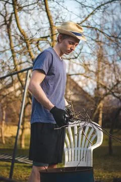 Hardworking man in work clothes uses loppers to split wood into smaller stick Stock Photos