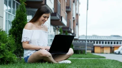 Hardworking student working on a laptop in campus sitting on the grass Stock Footage 111974628