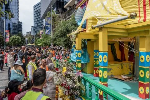 Hare Krishna devotees around a colofully decorated Indian religious float Stock Photos