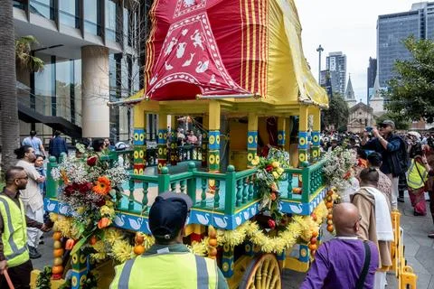 Hare Krishna devotees around a colofully decorated Indian religious float Stock-Fotos