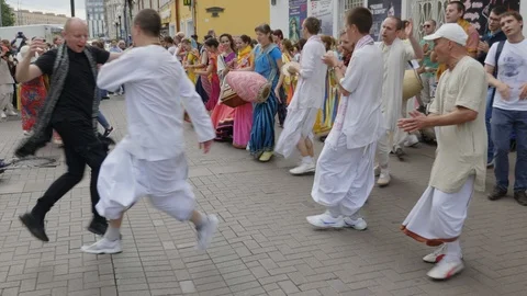 Hare Krishna devotees with hands held high, singing and dancing through the s Stock Footage 87353013