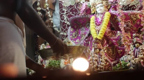 Hare Krishna statues with candles at foreground Stock Footage 60657855