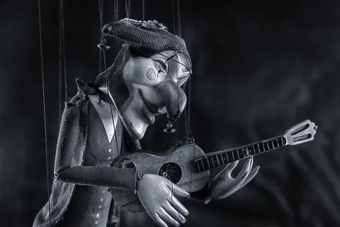 Harlequin puppet doll on strings with selective focus black and white Stock Photos