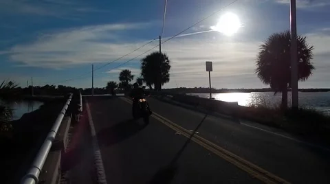 Harley davidson motorcycle riding next to shoreline Stock-Footage 45292497
