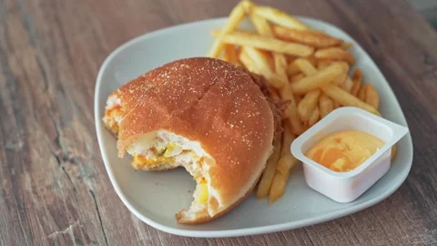 Harmful cheeseburger and fries. The hand dips the fried potatoes into the sauce Stock Footage 132436070