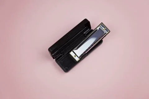 Harmonica in container on a pink background Stock Photos