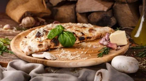 Harmonious composition of pizza Calzone, garlic, basil and cheese Stock Photos