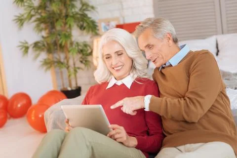 Harmonious retired couple using tablet computer together Foto stock