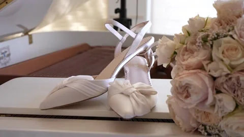 Harmony in Elegance: Bride's Shoes and Bokeh on White Piano Stockbeeldmateriaal 219438722