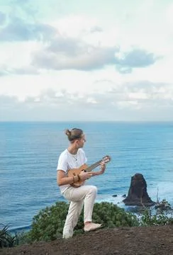 Harmony with Nature: A Vertical Frame Capturing a Solo young man Musician Playin Stockfoto's